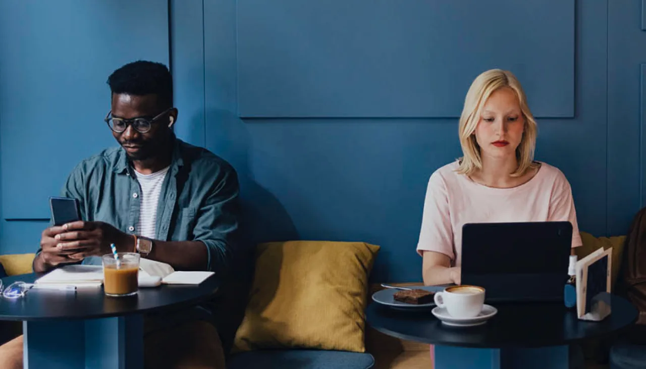 Man and woman working remotely from the cafe